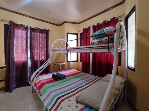 a bedroom with a bunk bed with a colorful blanket at Riverside at Aninuan Accommodation and Food in Puerto Galera