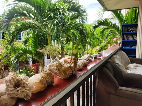 a balcony with rocks and palm trees and a couch at Riverside at Aninuan Accommodation and Food in Puerto Galera