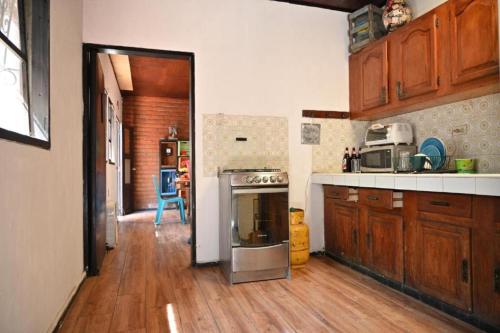 a kitchen with a sink and a stove top oven at Hostal Natural in Santa Ana