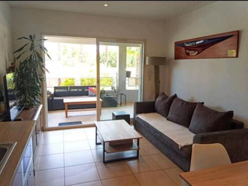 uma sala de estar com um sofá e uma mesa em U paradisu, T2 au calme avec accès privé mer em Biguglia