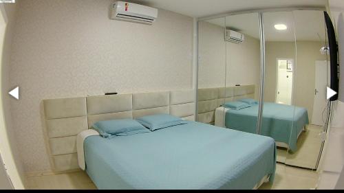 Habitación hospitalaria con cama y espejo en Excelente Apartamento Edf Bellagio - Praia do Morro, en Guarapari
