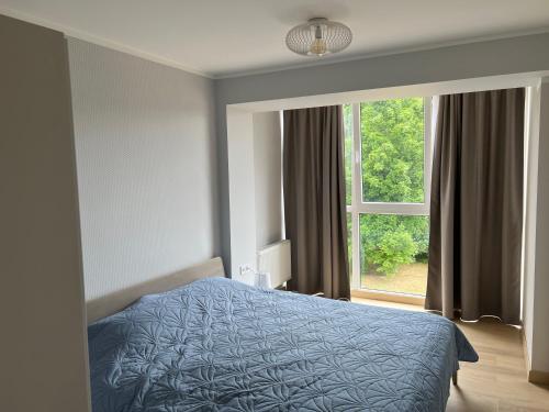 ein Schlafzimmer mit einem Bett und einem großen Fenster in der Unterkunft Roja Lux Apartment in Roja