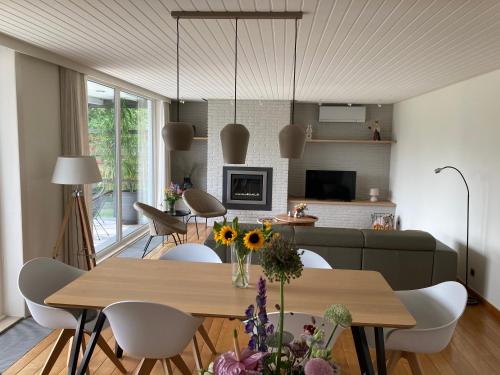 a dining room and living room with a table and chairs at Vakantiewoning De Papendaler in Zutendaal