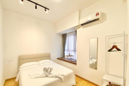 a white bedroom with a bed and a window at Cozy Beach Escape: 2BR Muji Gem in Johor Bahru
