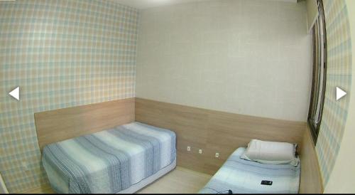 Habitación pequeña con 2 camas. en Excelente Apartamento Edf Bellagio - Praia do Morro, en Guarapari