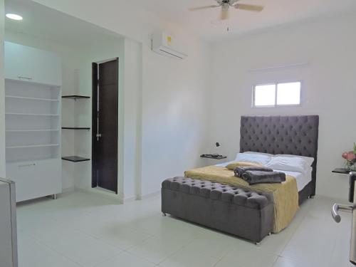 Apartahotel Baq Suite 44 في بارانكويلا: غرفة نوم بسرير في غرفة بيضاء
