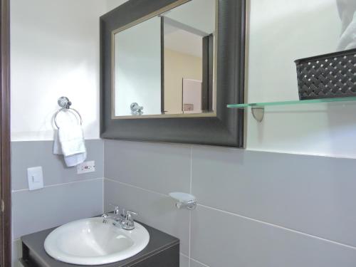 W łazience znajduje się umywalka i lustro. w obiekcie Apartahotel Baq Suite 44 w mieście Barranquilla