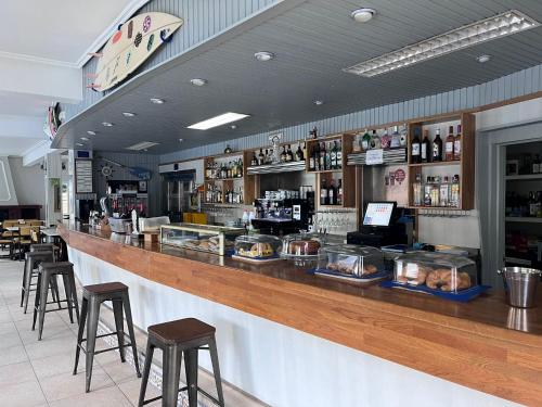 eine Bar in einem Restaurant mit Hockern und einer Theke in der Unterkunft Hostería Somo in Somo
