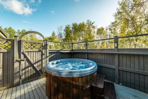 a hot tub on a deck with a fence at Beautiful family home in South-Iceland perfect for groups and families in Hella