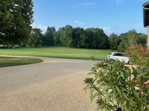 a white car parked in front of a driveway at La Maison du Lac in Flavignac