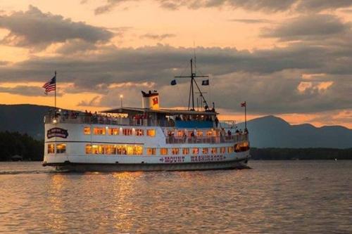 a cruise ship on the water at sunset at Beautiful Spacious Home w/ Game Room. in Gilford