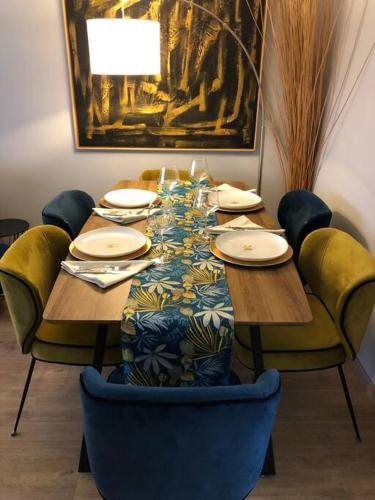 une table en bois avec des chaises et un chiffon de table. dans l'établissement Trendy apartment with 2 bedrooms,2 full bathrooms each with shower,toilet,sink, 500m from the centre, private secure parking, à Cannes