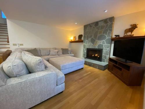 a living room with a couch and a fireplace at Beautiful Spacious Home w/ Game Room. in Gilford