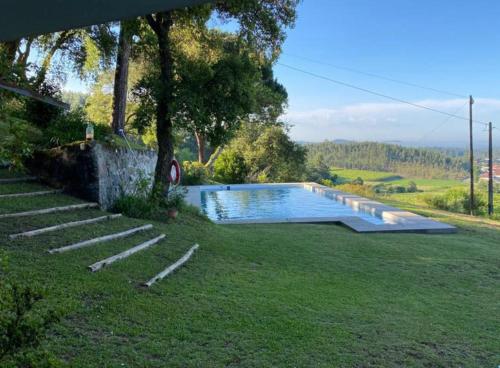 a swimming pool in a yard with some stairs at Casa Mata da Ribeira in Barcelos