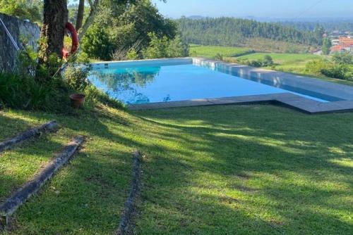 a swimming pool in the yard of a house at Casa Mata da Ribeira in Barcelos
