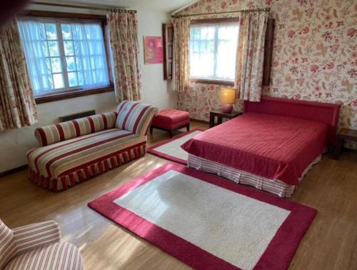 ein Schlafzimmer mit einem Bett und einem Sofa in der Unterkunft Casa Mata da Ribeira in Barcelos