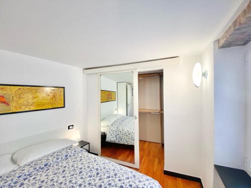 Un dormitorio con dos camas y un espejo. en CasaViva - Comfy Central Bilo in Genova, en Génova