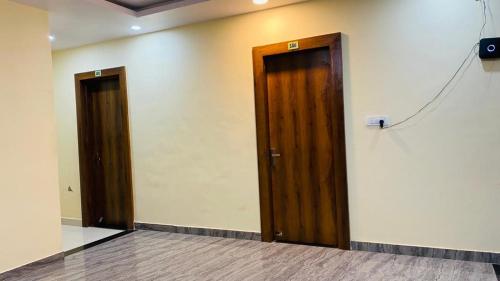 dwa drewniane drzwi w pokoju ze ścianą w obiekcie ANNPURNA RESIDENCY w mieście Datia