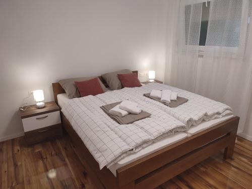 een slaapkamer met een groot bed met 2 kussens erop bij Apartmani CARPE DIEM in Draškovec