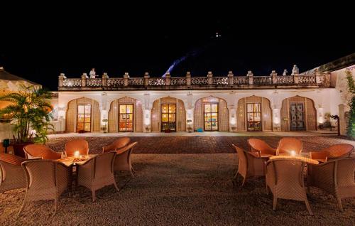 a group of chairs in front of a building at night at The Rawla Narlai - A Luxury Heritage Stay in Leopard Country in Nārlāi