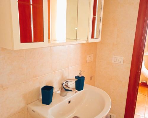 un lavandino in bagno con due tazze blu sopra di Casa Amalia a Boario Terme