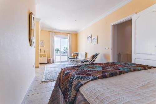um quarto com uma cama e uma cadeira num quarto em Casa Miguel em Frigiliana