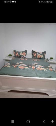 - un lit avec une couverture florale et des oreillers dans l'établissement Residence familiar Manu, à Tîrgu Neamţ