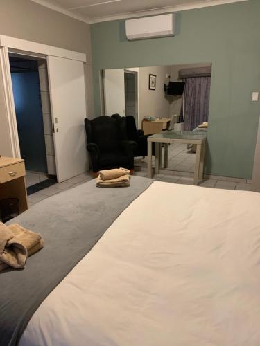 a bedroom with a bed and a living room at Hotel Pension Casa Africana in Windhoek