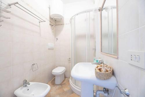 プロッキオにあるGli Oleandri di Procchioの洗面台とトイレを備えた白いバスルーム