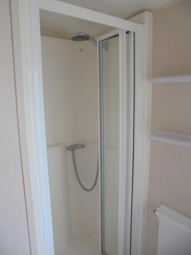 a shower with a glass door in a bathroom at Kingfisher : Vacation III:- 6 Berth, Close to site entrance in Ingoldmells