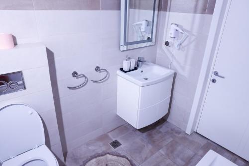 uma casa de banho branca com um WC e um lavatório em Apartament Mamaia-Nord em Mamaia Nord – Năvodari