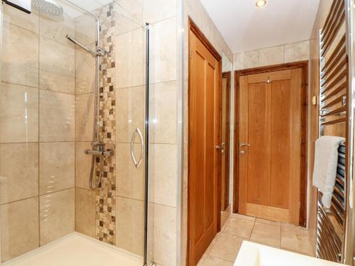 a bathroom with a shower with a glass door at Took Some Doing in Bodmin