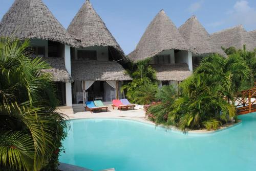 a resort with a swimming pool and some thatch huts at Swordfish Villas Samaki House (n.4) in Malindi