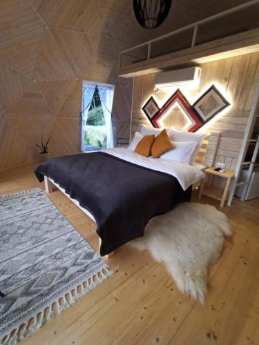 sypialnia z dużym łóżkiem i dywanem w obiekcie Honey dome w mieście Vizhenka