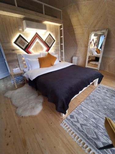 a bedroom with a large bed and a rug at Honey dome in Vizhenka