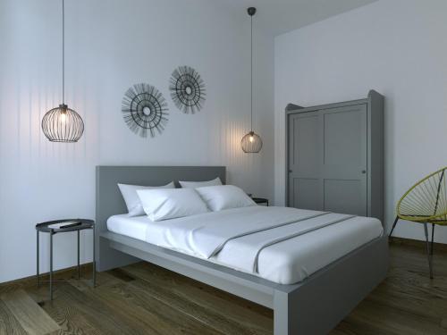 um quarto com uma grande cama branca e 2 luzes em Fenici Levanzo - Island Apartments em Levanzo