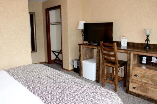 a hotel room with a bed and a desk with a television at Bayside Resort, Lake George NY in Lake George
