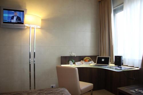 a room with a desk with a laptop and a tv at LH Hotel Sirio Venice in Mestre
