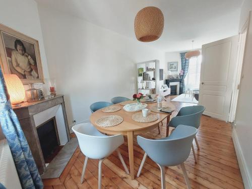 a dining room with a wooden table and chairs at Villa Capucine - Maison de ville avec jardin dans Vernon-Giverny, proche des transports et de la gare in Vernon
