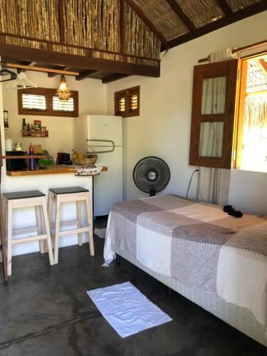 1 dormitorio con cama, mesa y cocina en Tribu Chales Atins en Atins