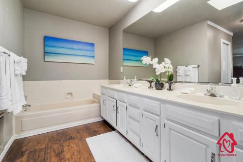uma casa de banho branca com 2 lavatórios, uma banheira e uma banheira tubermott em Casa Bonita - An Irvie Home em Albuquerque