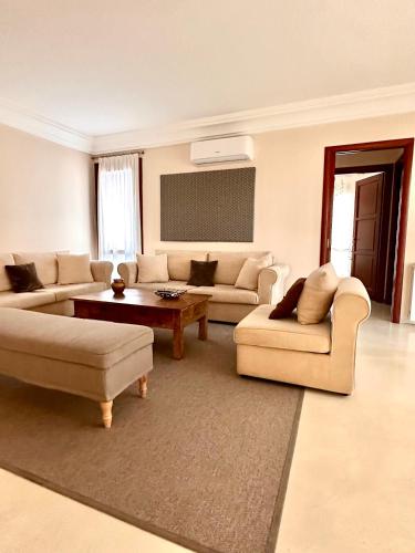 a living room with two couches and a table at Double A Luxury Apartment in Olbia