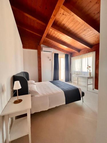 a bedroom with a large bed with a wooden ceiling at Labiente Suite & Breakfast in Peschici