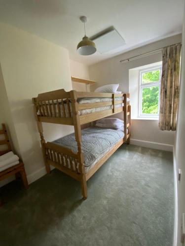 a bedroom with two bunk beds and a window at Willow Cottage in Longney
