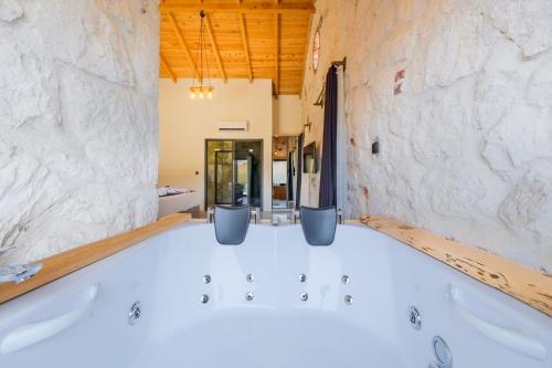 bañera en una habitación con pared de piedra en Fethiye Villa Ka Exclusive 2, en Fethiye