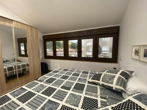 a bedroom with a bed and a mirror at APARTAMENTO El Roxu 2 in Arriondas