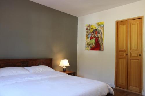 ein Schlafzimmer mit einem Bett und einem Wandgemälde in der Unterkunft Fleurs de Brenne Gite in Neuillé-le-Lierre