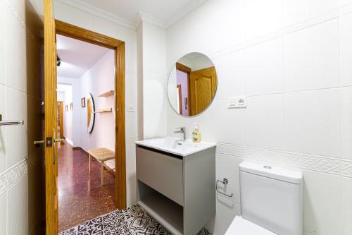 a bathroom with a toilet and a sink and a mirror at Trendy Homes Zapillo I - Playa a 5 minutos andando in Almería