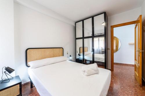 1 dormitorio con 1 cama blanca grande y espejo en Trendy Homes Zapillo I - Playa a 5 minutos andando en Almería