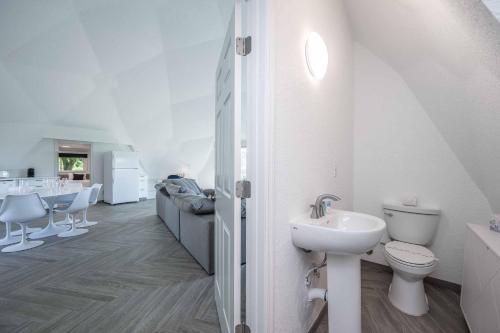 a white bathroom with a sink and a toilet at Sumner Lake Tiny House in Clermont